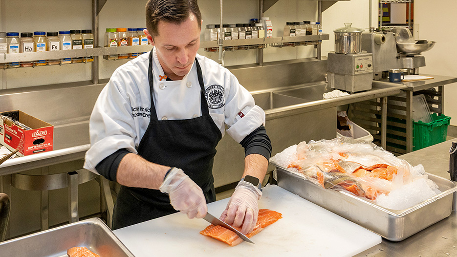 Chef Michael Hinrichs cuts a filet of salmon. 