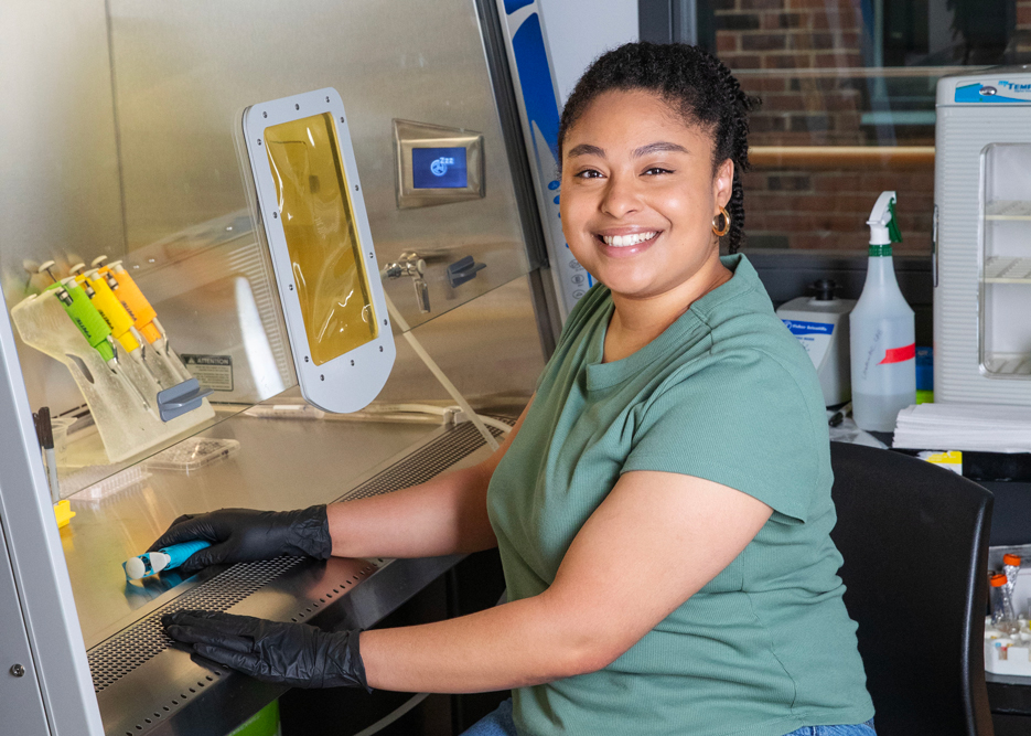 Kayla Melendez smiles as she sits at a lab table
