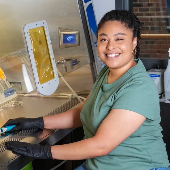 Kayla+Melendez+smiles+as+she+sits+at+a+lab+table