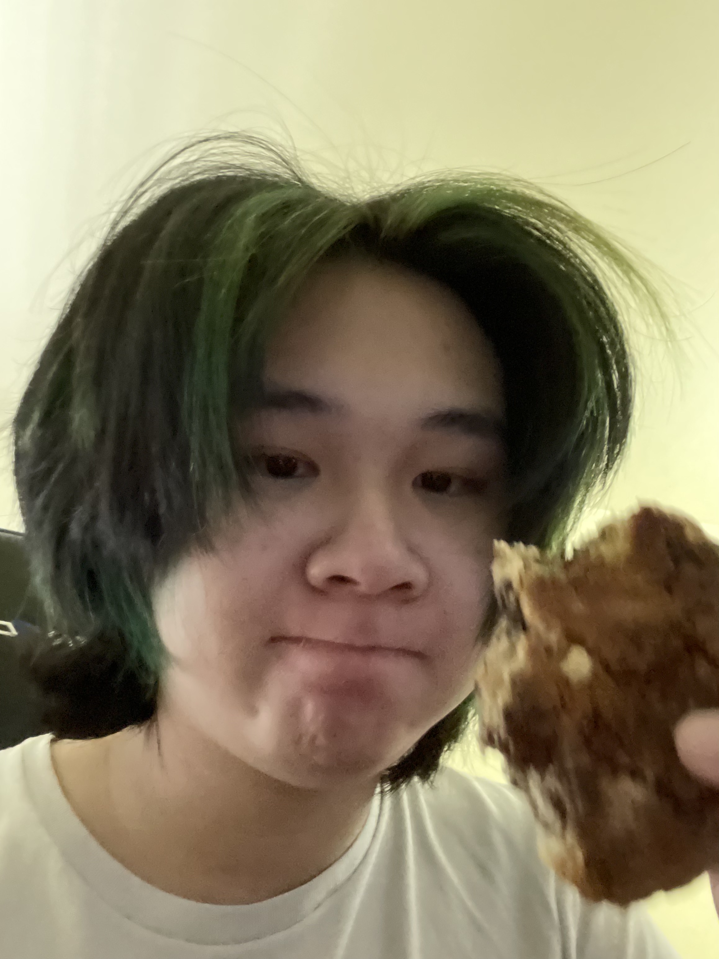 Ivan Picture of Ivan, an Asian student staff member with short black hair holding up a cookie