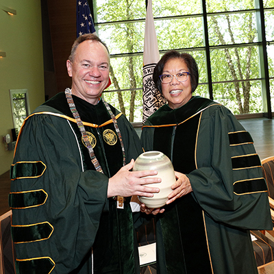 Millie Tan '77 accepting award from President Conner