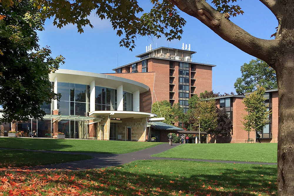 Exterior view of Skidmore College's Murray-Aikins Dining Hall, surrounded by green lawns and trees.