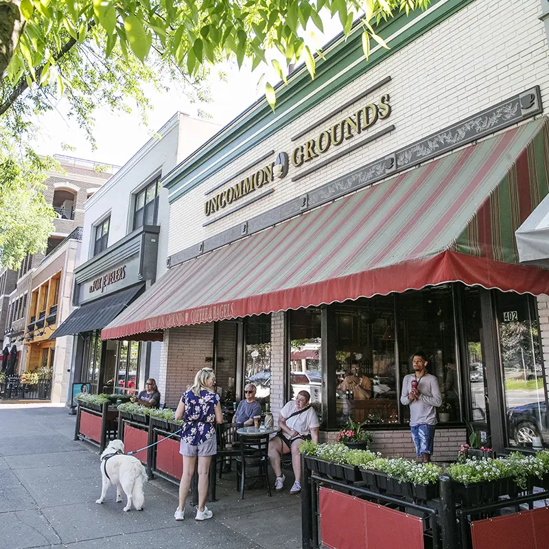 People relax with drinks and conversation outside Uncommon Grounds, a popular coffee and bagel spot in downtown Saratoga Springs