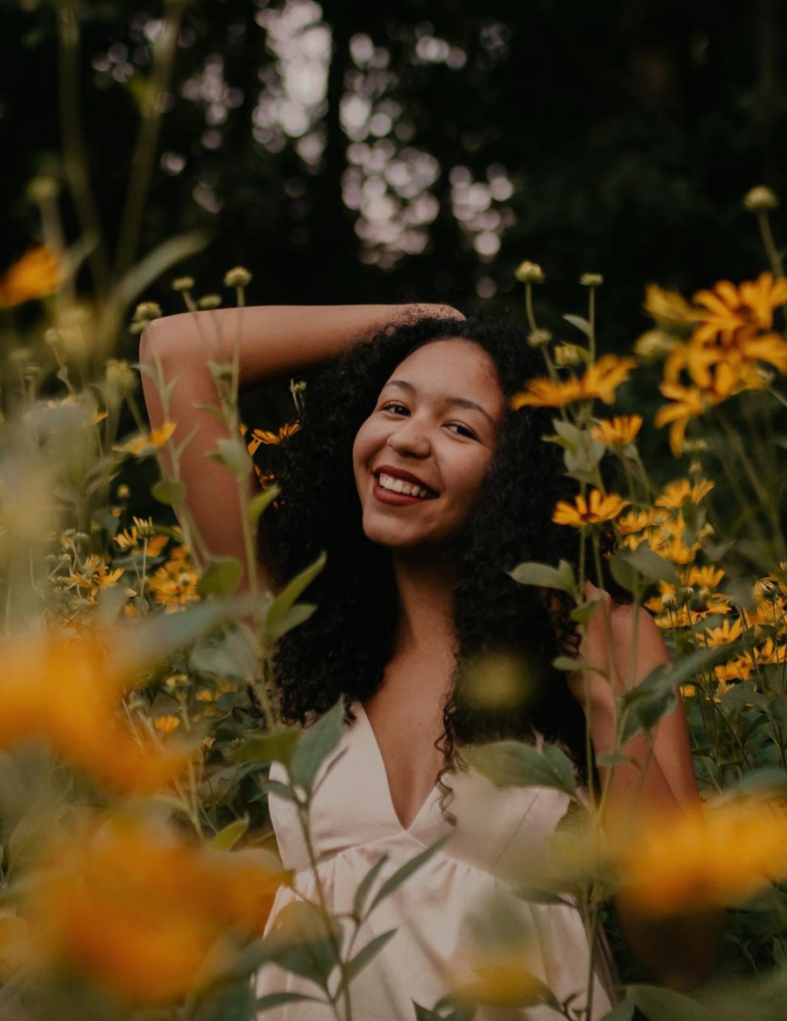 Marie Beech posing in a field of flowers