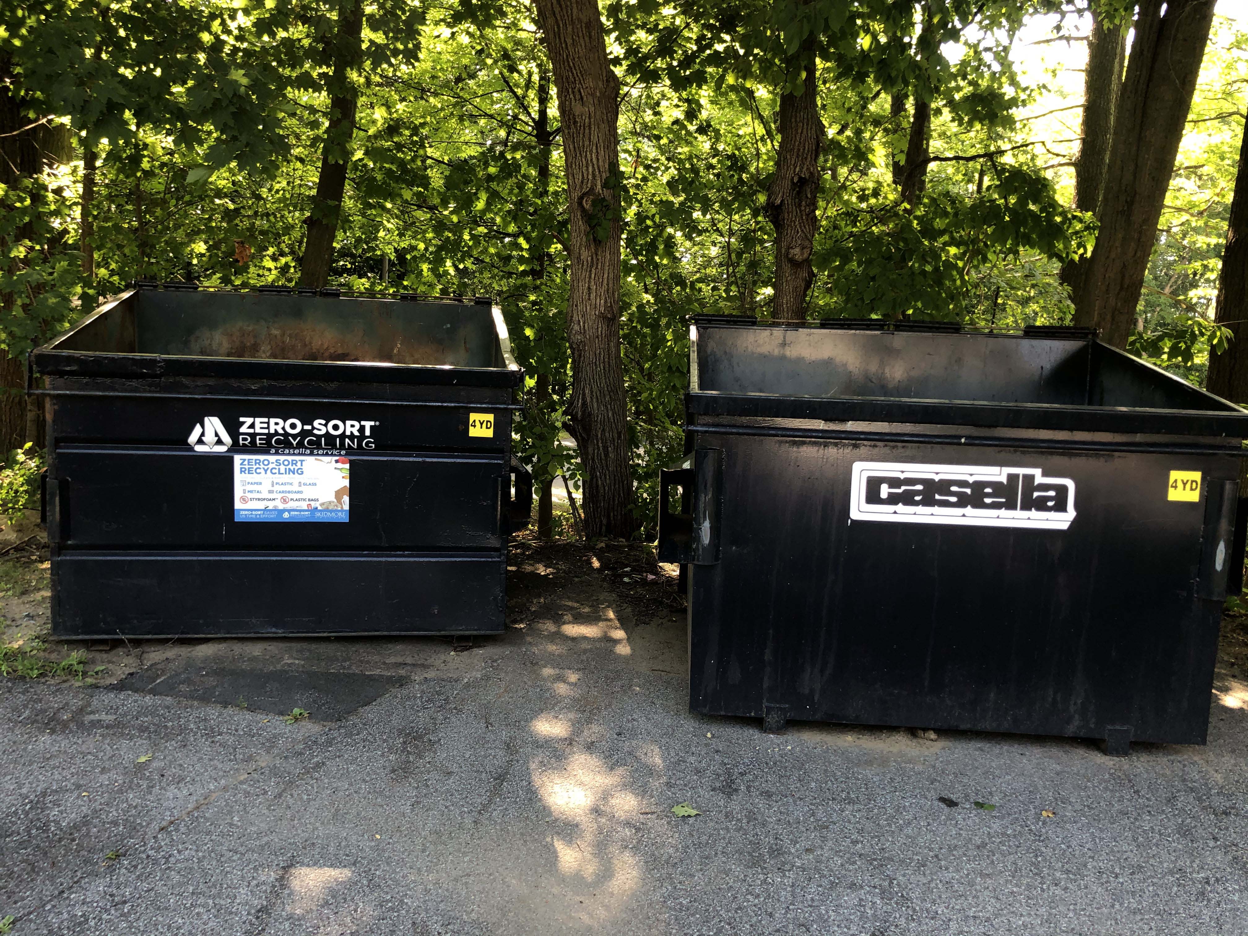 Two blue dumpsters side by side, one labelled landfill and the other recycling