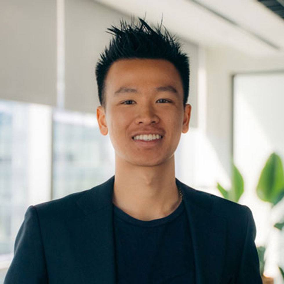 Alum Kevin Ha ’21 smiling while wearing a blue suit
